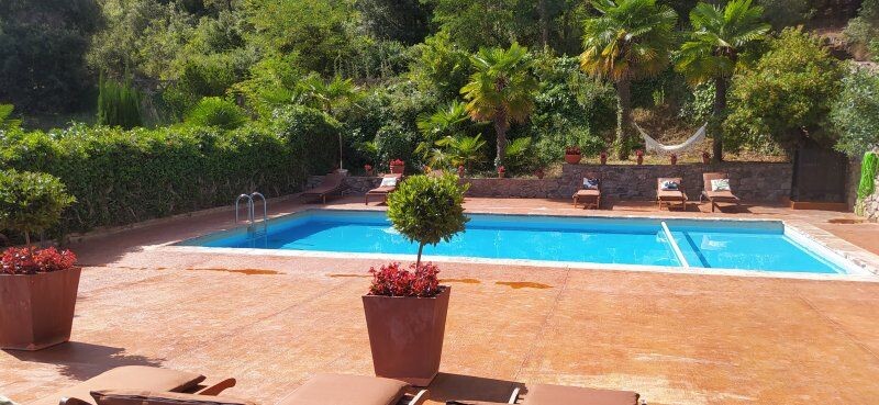 Panorámica de la zona de la piscina de la Masia Sagués en verano